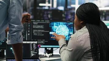 Data center manager supervising worker deploying AI solutions optimizing equipment. Server farm supervisor overseeing programmer using artificial intelligence to minimize systems downtime, camera B video
