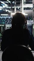 Vertical Data center engineer implements AI virtualization frameworks to optimize server clusters. Server hub IT professional doing artificial intelligence predictive analysis, camera A video