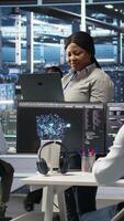 Vertical Data center computer scientists use node tree programming to identify equipment performance issues. Server farm employees review data analysis graphs to minimize infrastructure failures, camera A video