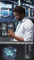 Vertical Server farm technician using AI algorithms and node tree systems to categorize unstructured data. Data center worker uses visual programming and natural language processing tools, camera A video