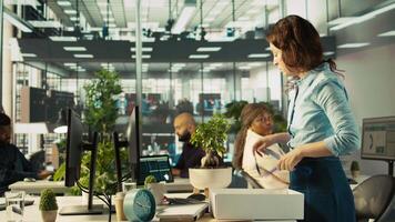 Employee getting consoled by colleagues after being fired, leaving office. Worker holding box filled with desk plants saying goodbye to coworkers after being laid off, camera B video