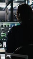 Vertical Stressed server hub admin worried by malfunctioning data analytics AI generator. Anxious data center worker concerned by critical error in artificial intelligence tool showing system metrics, camera B video