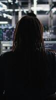 Vertical Data center system administrator using machine learning algorithms to analyze large datasets. Server farm worker using AI neural networks on computer to recognize data patterns, camera A video