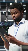 vertical dados Centro engenheiro usando tábua para interpretar dados analytics gráficos. servidor quarto trabalhador usando artificial inteligência exibindo sistema desempenho preditivo Métricas, Câmera b video
