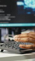 Vertical Data center computer scientist at desk using AI deep learning algorithms to analyze datasets. Server room IT specialist typing on PC keyboard, using artificial intelligence neural networks, camera B video