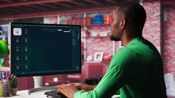 Black graphic designer working in loft with AI image generator software. Digital screen displaying visuals created through machine learning and cloud computing, . Camera A. video