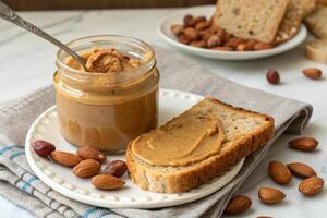 jar of organic nut butter with spoonful spread on whole grain bread, surrounded by almonds. This healthy snack is perfect for breakfast or quick energy boost photo