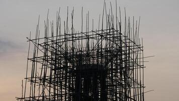 A silhouette of construction site with scaffolding against sunset sky, showcasing intricate structure of framework. scene evokes sense of progress and development photo