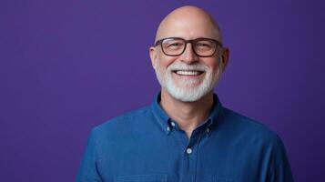 Older man with glasses smiling against a vibrant purple background, showcasing warmth and confidence in a studio setting photo