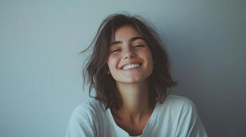 Young woman smiles brightly indoors, showcasing a joyful expression and natural beauty in a relaxed setting photo