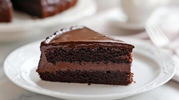 Decadent chocolate layer cake slice served on a delicate plate in a cozy kitchen setting photo
