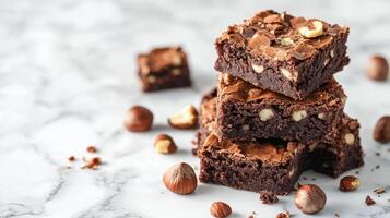 Decadent chocolate brownies stacked with hazelnuts on a marble surface photo