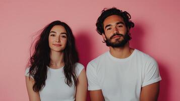 Stylish young couple posing confidently against a vibrant pink background in a modern studio setting photo