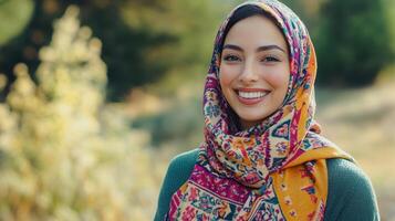 Young woman wearing a colorful scarf smiles warmly in a lush outdoor setting during daylight hours photo