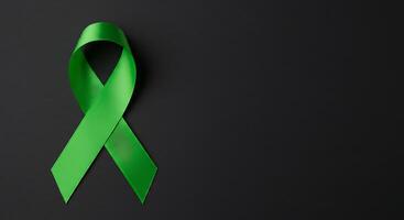 Green Ribbon on Black Background Symbolizing Support and Awareness Campaign photo