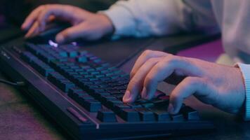 Close up male hands typing keyboard in neon light man guy hacker worker businessman streamer gamer business working desktop computer modern playing game online internet chatting cropped view video