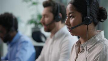 Close up smiling multiethnic team group operators diverse callcenter workers headset microphone consulting customer online service sales Indian business woman Caucasian African assistant call center video