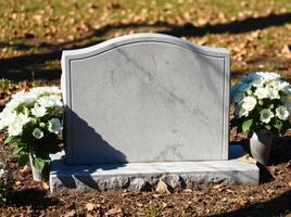 A grave with flowers and a tombstone photo