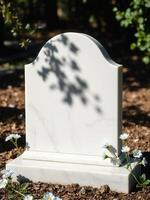A white marble tombstone with blue flowers in the foreground photo