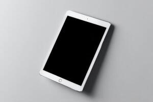 Tablet resting on a smooth surface in a modern workspace during daylight hours photo