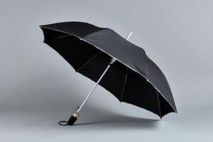 Travel umbrella folded and isolated against a simple grey background for storage or transport photo