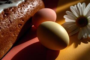 Bright sunlit flat lay of decorated eggs and a cake with a daisy flower photo