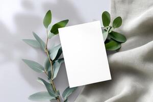 Minimalist design with blank card framed by greenery on a soft, light background photo