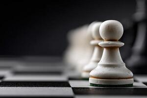 White pawns lined up on a chessboard ready for strategic gameplay in a dark setting photo