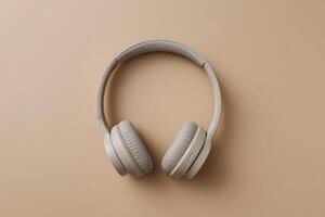 High-quality beige wireless headphones on a smooth tan background photo