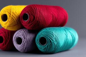 Colorful yarn spools arranged creatively in a stack on a neutral background photo