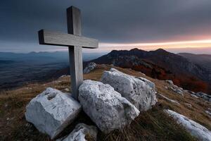 Weathered wooden Orthodox cross stands prominently on rocky terrain at dusk photo