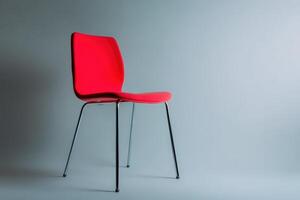 Bright red chair with sleek design showcased against a minimalist gray background photo