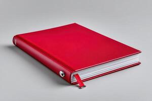 Red closed book resting on soft natural surface inviting curiosity and exploration of its content photo