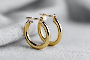 Gold hoop earrings on soft fabric showcase their elegant shine and style photo