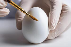 Creating intricate designs on a white egg using a fine brush for decoration photo