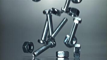 Falling nuts, bolts and washers on a metal table. Filmed on a high-speed camera at 1000 fps. High quality FullHD footage video