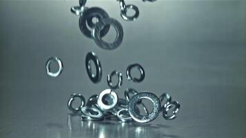 Metal washers fall on the table. Filmed on a high-speed camera at 1000 fps. High quality FullHD footage video