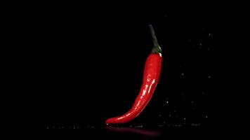 Red chili peppers fall on the table. Filmed on a high-speed camera at 1000 fps. High quality FullHD footage video