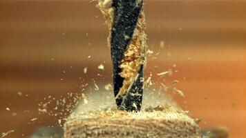 Drilling a wooden block in the workshop. Filmed on a high-speed camera at 1000 fps. High quality FullHD footage video