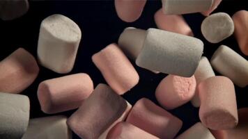 Pink and white marshmallows fly up and fall down. Filmed on a high-speed camera at 1000 fps. High quality FullHD footage video