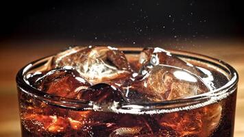 A glass of cola with ice. Splashes on the surface. Filmed on a high-speed camera at 1000 fps. High quality FullHD footage video
