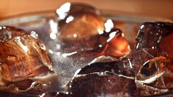 A glass of cola with ice. Splashes on the surface. Filmed on a high-speed camera at 1000 fps. High quality FullHD footage video