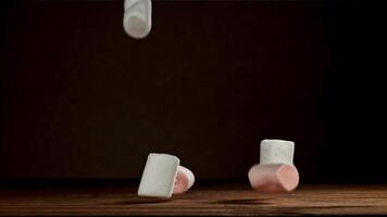 Marshmallows fall on a wooden table. Filmed on a high-speed camera at 1000 fps. High quality FullHD footage video
