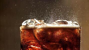 A glass of cola with ice. Splashes on the surface. Filmed on a high-speed camera at 1000 fps. High quality FullHD footage video