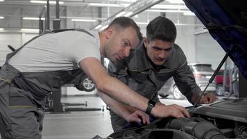 bil mekanik intensivt diskutera en bruten bil medan inspekterande de motor video