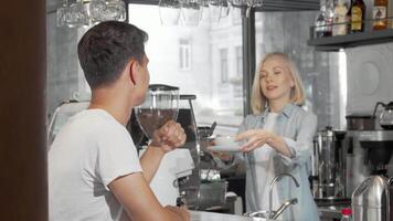 Charming young man smiling at the camera while savoring his coffee in a cozy cafe video