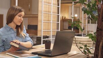 Caucasian girl closes the book while working at a modern hub video