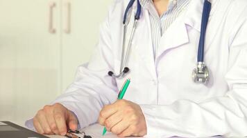 Dedicated male doctor diligently noting patient details video