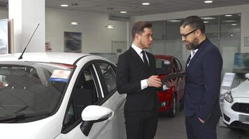 Sales manager explains the contract to the customer at the car dealership video