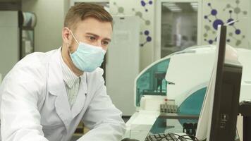 Focused laboratory worker analyzes test results on a computer video